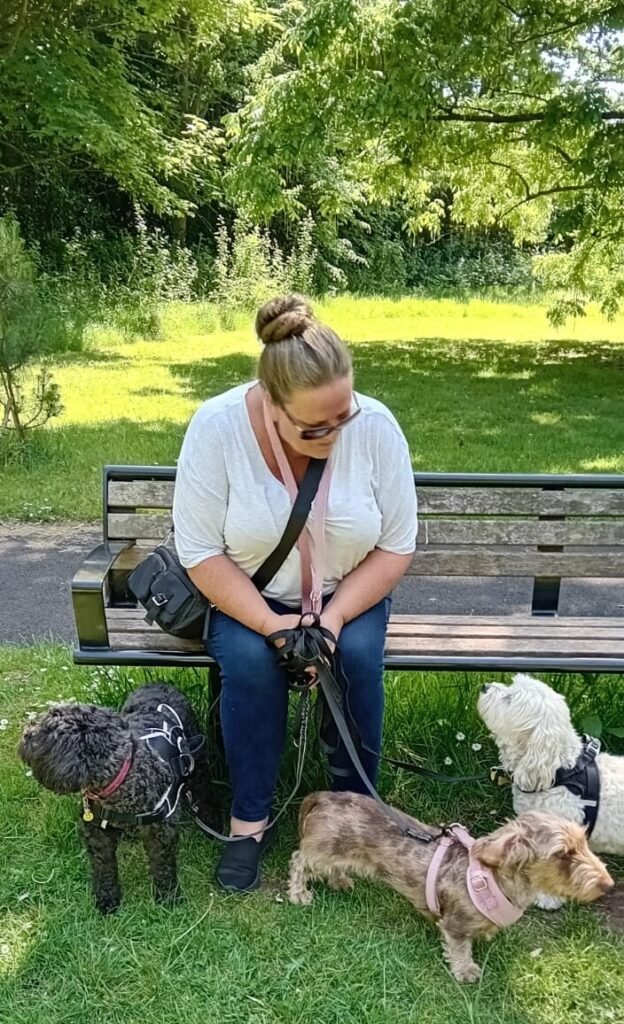 A dog and the Jackson Tiny Tails owner sitting together, enjoying a quiet moment in the park.